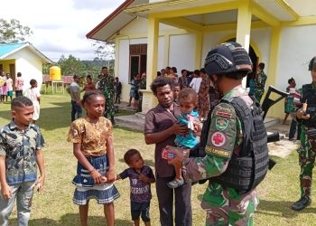 Keseruan Satgas Yonif 310/KK Bagikan Makanan Untuk Anak Di Perbatasan Usai Ibadah Bersama