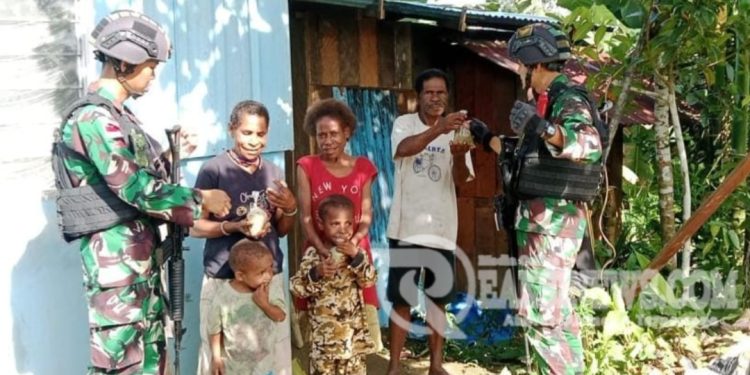 Beri Asupan Gizi Tambahan, Satgas Yonif 310/KK Keliling Kampung Bagikan Bubur Kacang Hijau